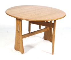 A mid-century Ercol light oak oval gateleg dining table.