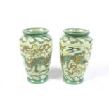 A pair of Charlotte Rhead Ducal vases. Having tube-lined decoration of dragons on a green ground.