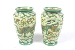 A pair of Charlotte Rhead Ducal vases. Having tube-lined decoration of dragons on a green ground.