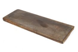 A thick wooden plank, possibly a butcher's block.
