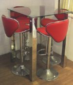 A set of four adjustable red vinyl kitchen stools and a glass top table.