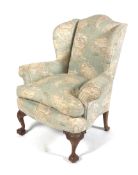 An early 20th century upholstered George I style upholstered wingback chair.