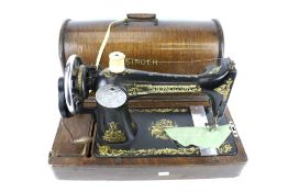 A circa 1915 Singer sewing machine in a wooden carry case. L45.