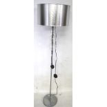 A contemporary chrome standard lamp.