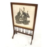 A wooden framed fire screen. Featuring a picture of an Indian figure, raised on swept supports, H93.