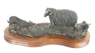 A Border Fine Arts Limited Edition bronzed effect model of a sheep and a sheep dog.