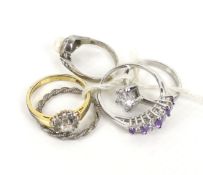A collection of five silver and yellow metal rings.