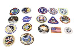 A collection of NASA mission patches and cloth badges.