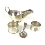 A silver sauce boat, two napkin rings and a christening spoon.