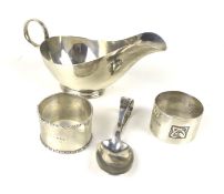 A silver sauce boat, two napkin rings and a christening spoon.