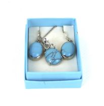 A pair of oval cabochon turquoise pendent earrings and a matching pendant.