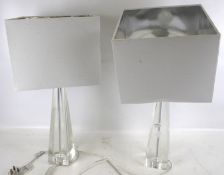 A pair of clear glass table lamp bases. With square shades.