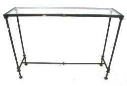 A contemporary metal framed and glass topped console table.