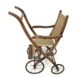 An Edwardian wood and canvas folding child's pushchair.