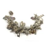 A silver 'charm' bracelet, hung with a large quantity of charms.