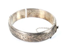A vintage silver foliate engraved hollow hinged bangle. Hallmarks for Birmingham 1965, approx. 18.