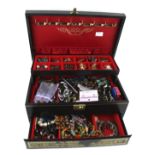 A black leather bound jewellery box containing a quantity of costume jewellery.