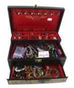 A black leather bound jewellery box containing a quantity of costume jewellery.