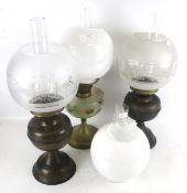Three oil lamps and four glass shades.