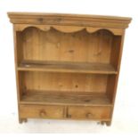 A pine wall shelf unit. With a single shelf positioned over two drawers.