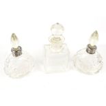 A pair of early 20th century silver mounted clear cut glass drop-shaped scent bottles and faceted