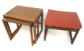 A mid-century nest of two tables and a stool with red leatherette upholstery.
