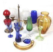 An assortment of glassware. Including a red glass oil lamp, a uranium glass candlestick, etc.