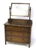 A 20th century oak chest of drawers mounted with a dressing mirror.