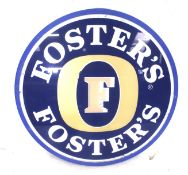 A round plastic Fosters beer sign.