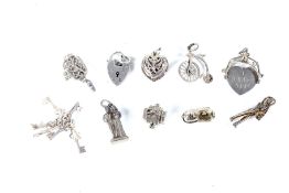 Ten silver and white metal charms. Including a soldier, church, camera, heart, etc. 32.
