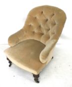 An Edwardian button back armchair on casters.