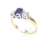 A modern 18ct white and yellow gold, sapphire and diamond three stone ring.