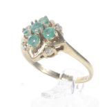 A modern 9ct gold, emerald and diamond cluster ring.
