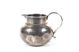An early 20th centuy Arts and Crafts silver milk jug by the Guild of Handicrafts.