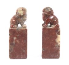A pair of rouge stone seals with Dogs of Fo finials. Unmarked under, 8cm high, 2.