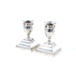 A pair of silver short candlesticks in neo-classical style.