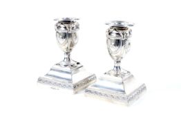 A pair of silver short candlesticks in neo-classical style.