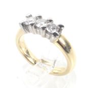 A modern 18ct white and yellow gold and diamond three stone ring. The three round brilliants approx.