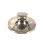 A silver round capstan shaped inkwell.