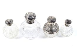 A group of four Victorian and later silver mounted clear cut-glass globular scent bottles.