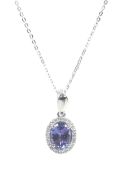 A modern platinum, tanzanite and diamond oval cluster pendant and chain.