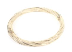 A vintage Italian gold textured spiral-twist hollow tubular hinged bangle.