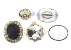 Four Victorian and later brooches and an Edwardian gold double-sided locket pendant.