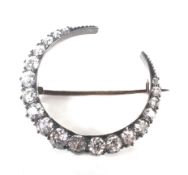 A late Victorian diamond closed-crescent brooch. The 19 graduated old-cut diamonds approx. 2.