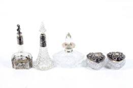 Three early 20th century silver mounted clear glass scent bottles and a pair of heart-shaped