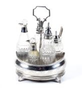 A George III silver oval cruet stand and five silver mounted bottles.