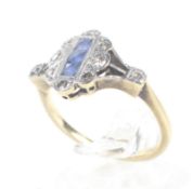 An Art Deco sapphire and diamond shaped-oval cluster ring with diamond shoulders.