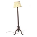An early 20th century mahogany tripod standard lamp. With fluted column and pleated silk shade.