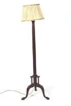 An early 20th century mahogany tripod standard lamp. With fluted column and pleated silk shade.