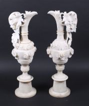 A large pair of cream alabaster ewers. With fruiting vine decoration and raised on round socles.